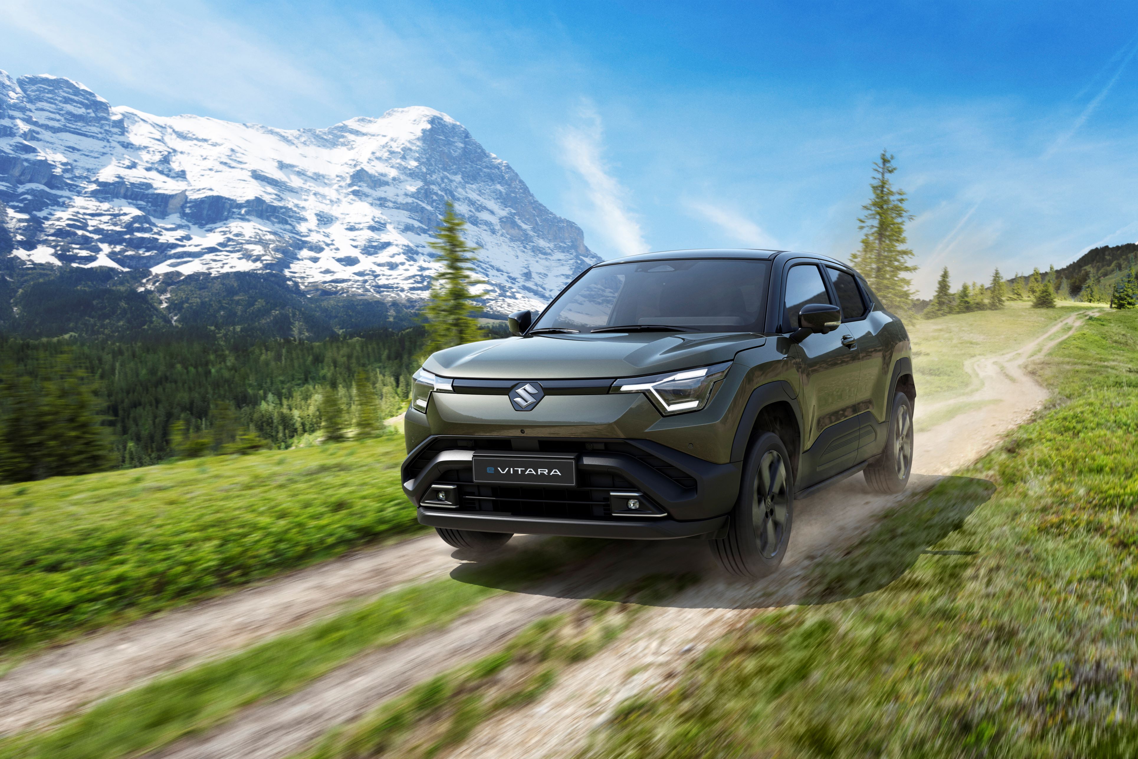 SUV driving on a dirt path in a mountainous area.