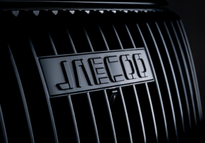 Close-up of a vehicle grille featuring a stylised brand logo in the centre.