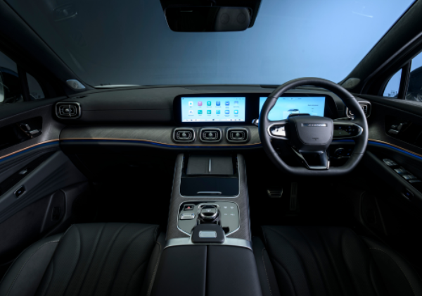 Car interior showing digital dashboard, steering wheel, and infotainment screens.