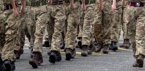 Soldiers in camouflage uniforms marching in formation.