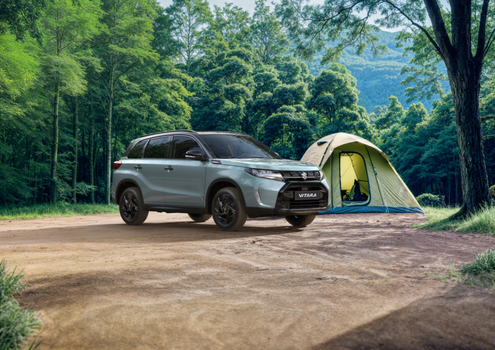 SUV parked next to a green camping tent in a forest clearing.